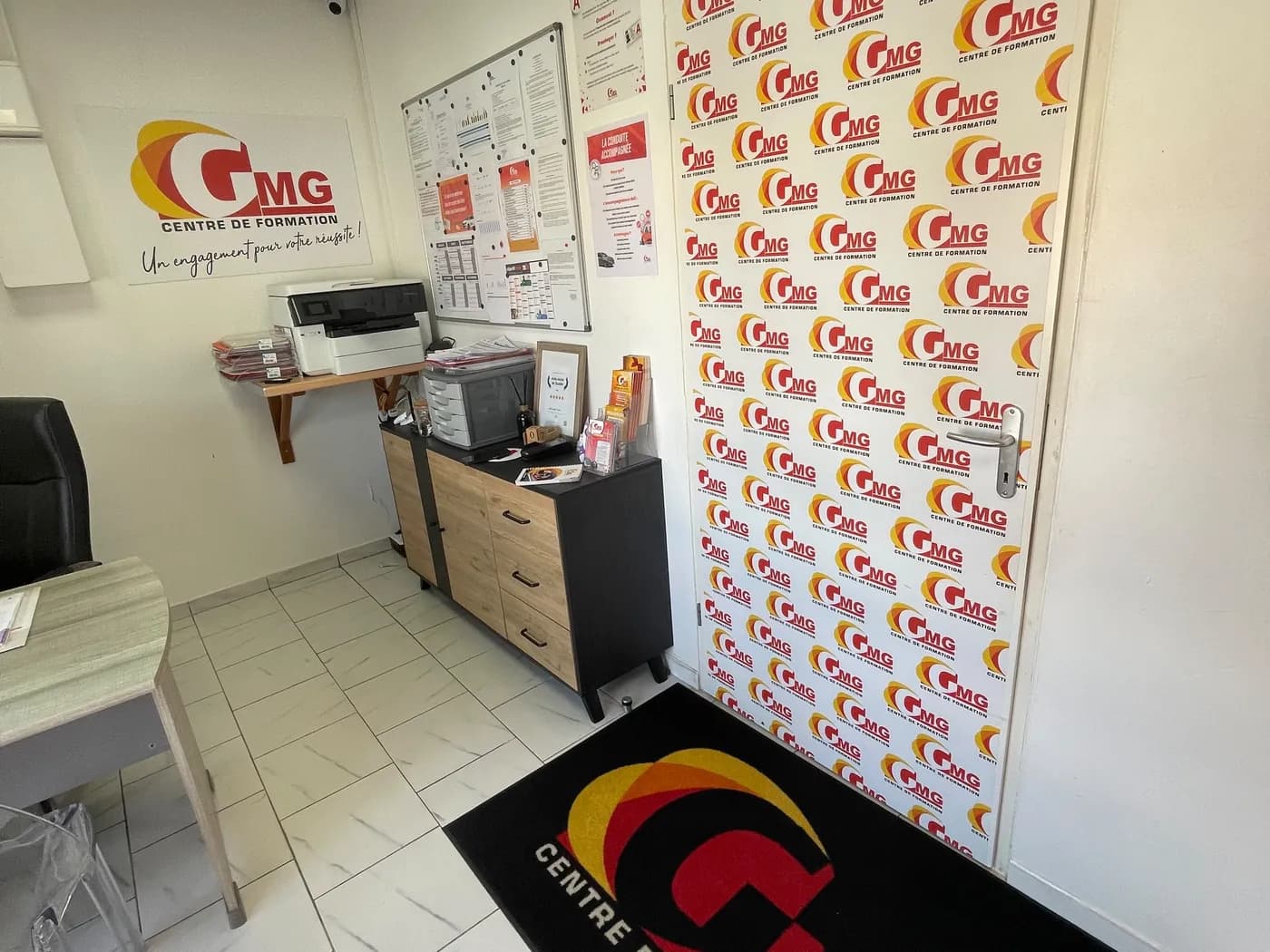 Bureau devant le mur aux logos GMG — Capesterre-Belle-Eau